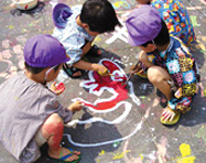 地面に絵を描く子どもの写真